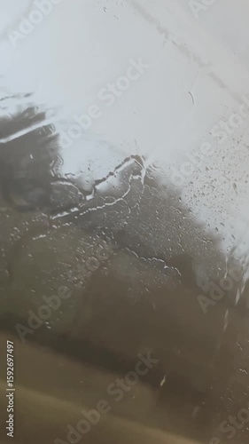 Rain on the window in a moving transport. Raindrops on the glass in a train