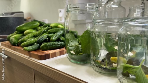 Fresh cucumbers and jars with herbs ready for pickling, capturing a homesteading vibe and sustainable living theme