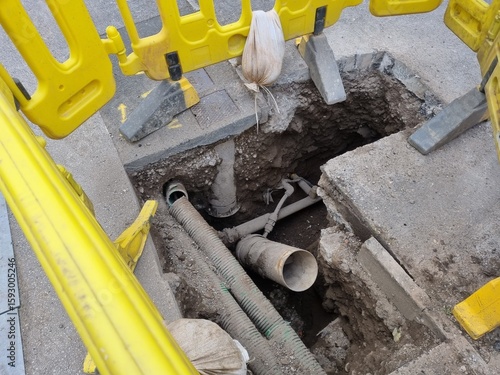 View inside an open utility access point, revealing infrastructure and piping.