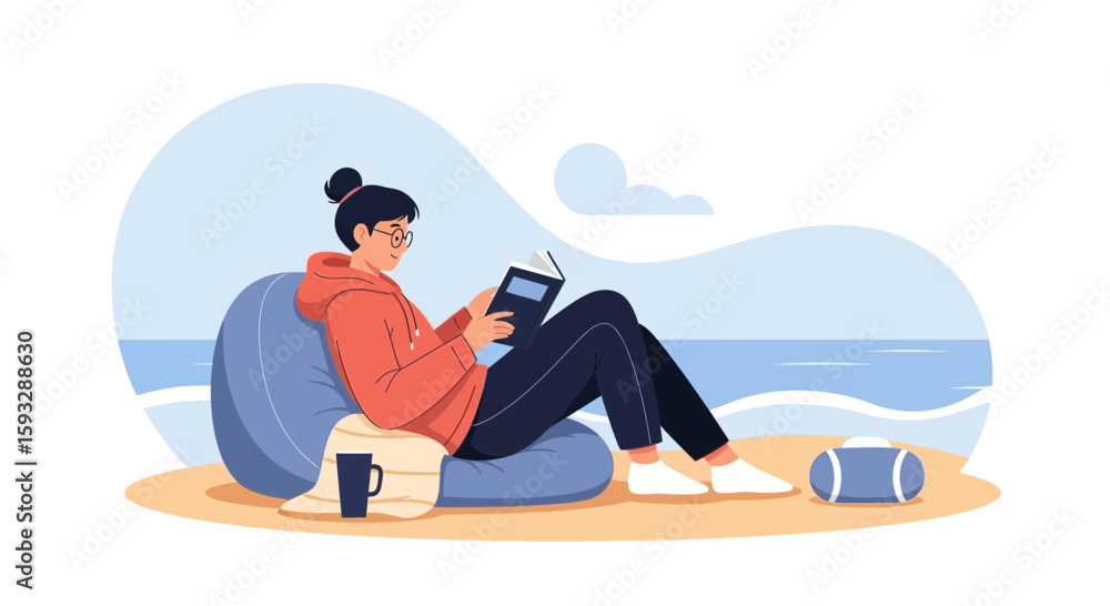 Fototapeta premium Woman Enjoying Leisure Time Reading At The Beach On A Comfortable Bean Bag