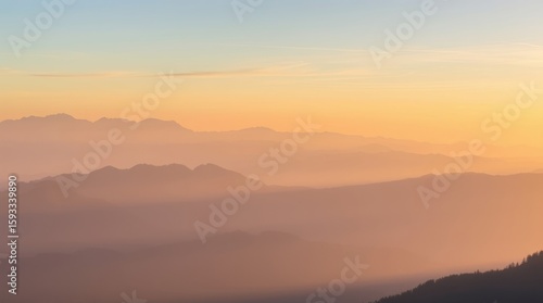 Mountain Sunrise: Capturing the essence of tranquility, this photo reveals layered mountain peaks bathed in the soft, golden hues of a tranquil dawn.