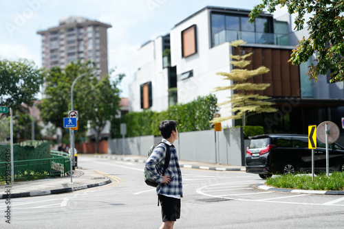 Wallpaper Mural Man standing at a street pedestrians in a residential area with modern houses and a high-rise building Torontodigital.ca