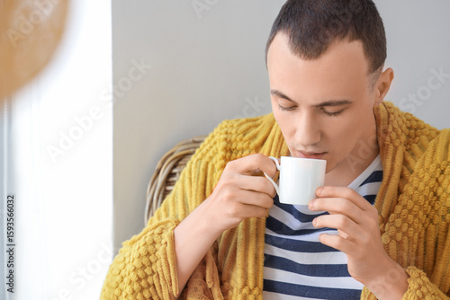 Young man with plaid drinki...