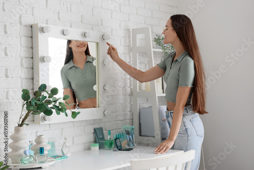 Young woman near mirror in ...