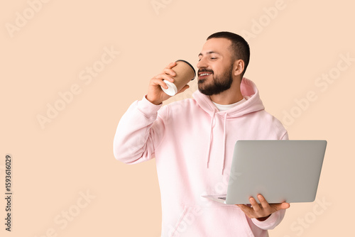 Young man with laptop drink...