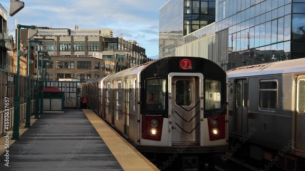 train arriving on platform in court square queens long island city new york nyc famous outdoor elevated station stop seven 7 metro commuter line tall buildings in background tracks railroad track