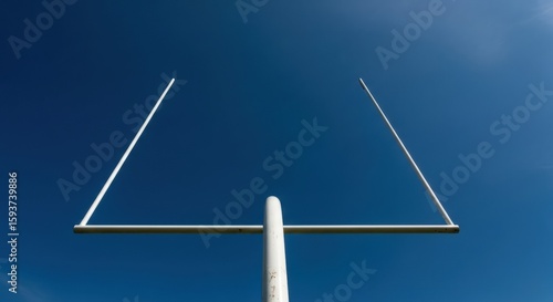 American football goal posts against a clear blue sky