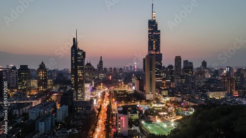 Aerial timelapse capturing Nanjing's Zifeng Building illuminated at night with city skyline