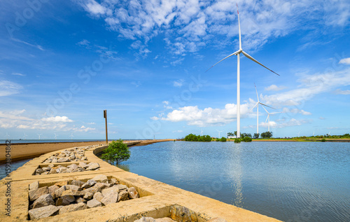 Coastal landscape with breakwaters and wind turbines in Ben Tre province, Vietnam.