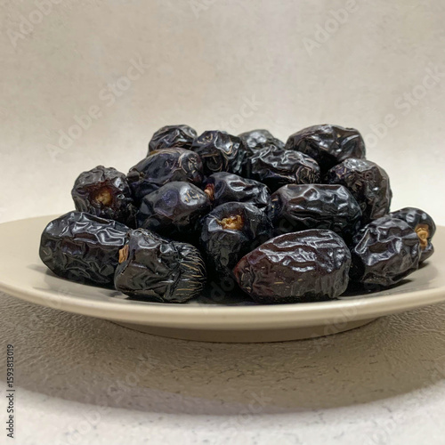 close up photo of a pile of Ajwa dates on a plate. ready to be served.