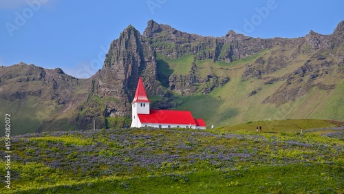 Red-roofed church under the mountains in Iceland