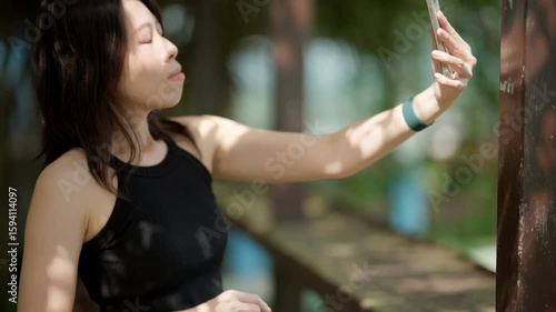 Woman Enjoying a Video Call on Her Smartphone from a Rustic Wooden Balcony.