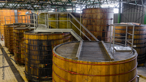 Canvas Print Grandes cuves en bois alignées à l’intérieur d’une installation artisanale ou industrielle dédiée à la fermentation ou à la production de boissons