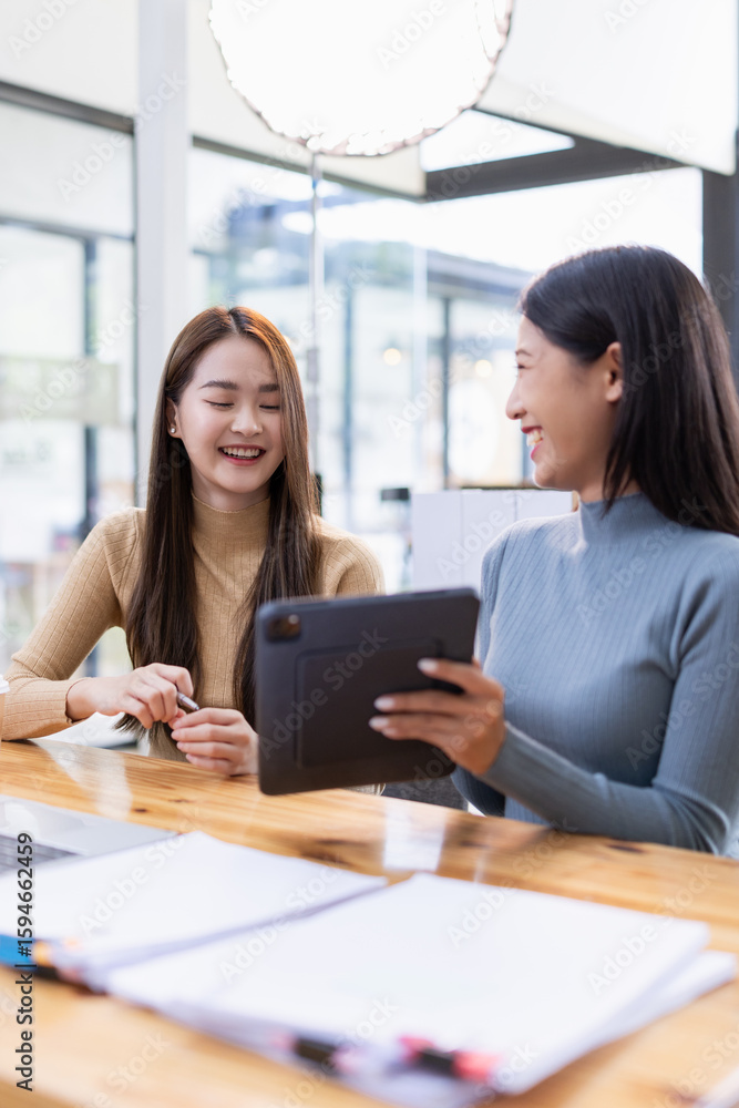 Two Asian young businesswoman using laptop computer working in office, Two Asian young businesswoman using laptop computer working in office,