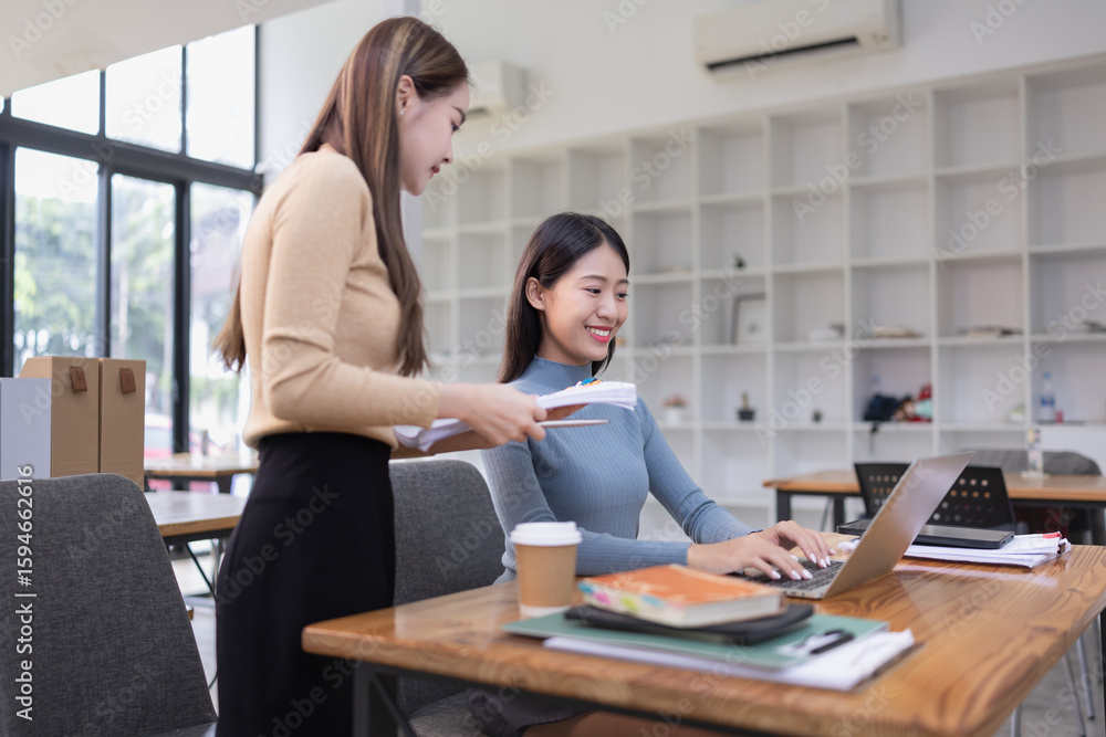 Fototapeta premium Two Asian young businesswoman using laptop computer working in office,