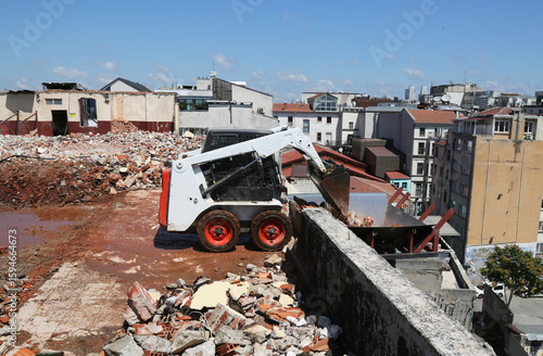 skid steer loader working construction site. mini loader transports excavation waste at construction site. compact loader. skeed steer workingi on site. compact construction machinery.