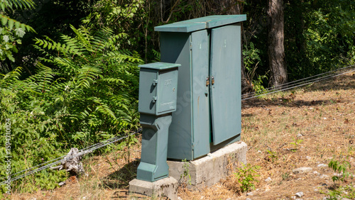 Aging electrical box basks in sunlit abandonment, a silent sentinel of forgotten technology, Earth Day recycling potential ignites intrigue