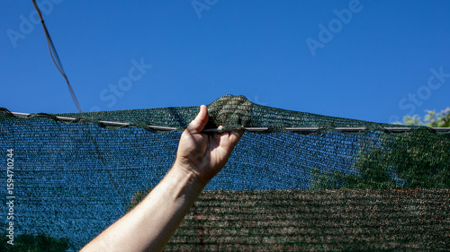 A Caucasian male hand levitates a steadfast stone over taut netting, evoking the enigmatic spirit of Kamehameha Day