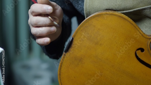 Obraz na plátně Skilled luthier carefully applying varnish to vintage violin, preserving delicat