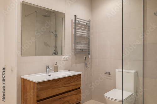 Wallpaper Mural Bathroom with wood vanity, chrome towel warmer, glass shower and beige tiled walls Torontodigital.ca