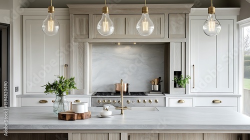 Coastal-inspired kitchen design with matte white cabinetry, driftwood grey marble surfaces, sandy-toned oak island and glass bulb pendant lights.