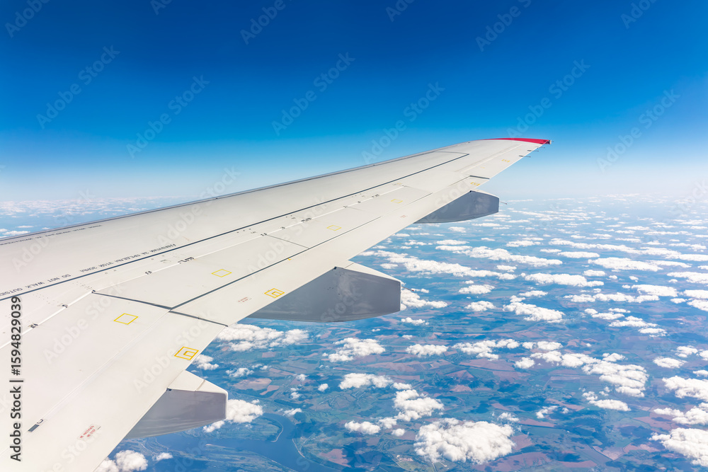 Obraz premium View from the airplane window at a beautiful cloudy sky and the airplane wing