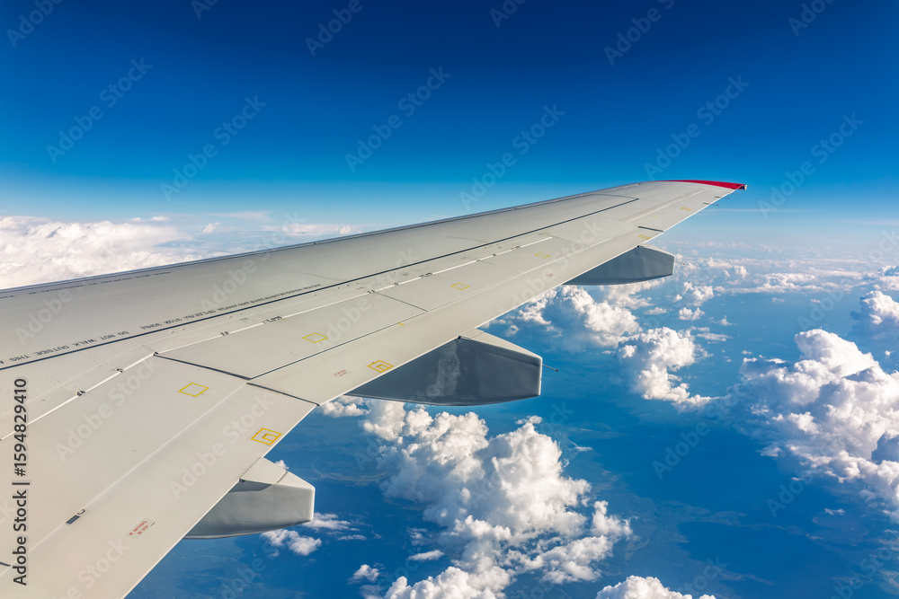 Obraz premium View from the airplane window at a beautiful cloudy sky and the airplane wing