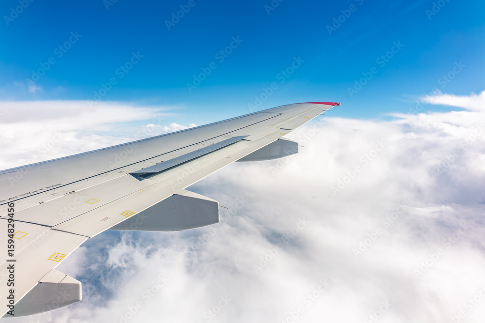 View from the airplane window at a beautiful cloudy sky and the airplane wing View from the airplane window at a beautiful cloudy sky and the airplane wing
