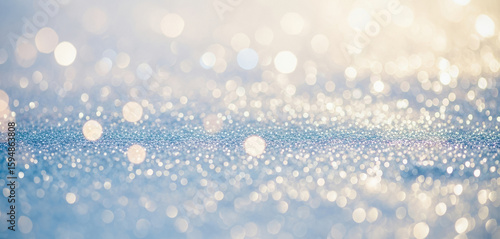 Abstract background with blurred lights in shades of blue, white, and gold, evoking a festive and elegant atmosphere suitable for luxury branding, seasonal graphics, or celebration designs.