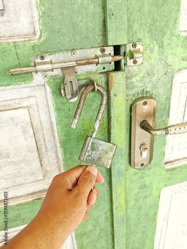 A man's hand unlocking a door
