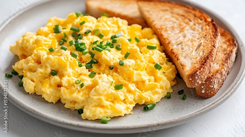 Fluffy Scrambled Eggs with Chives and Toast on a Plate