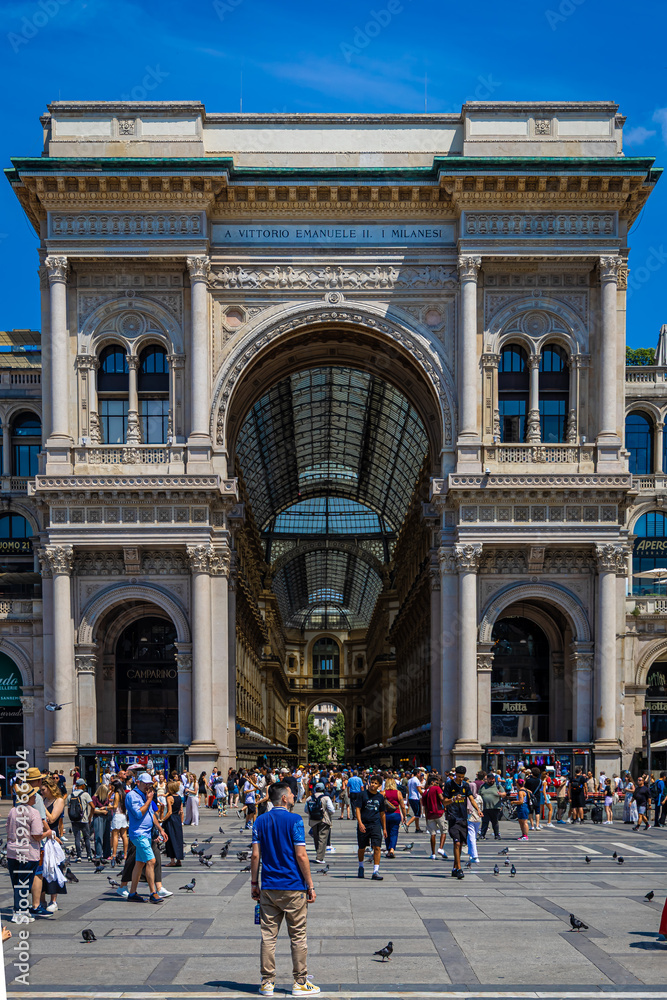 Obraz premium Interior view of Galleria Vittorio Emanuele II in Milan with glass dome, ornate facades, and decorative fresco under bright daylight