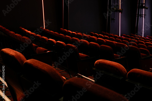 Empty Movie Theater With Rows of Cushioned Red Seats