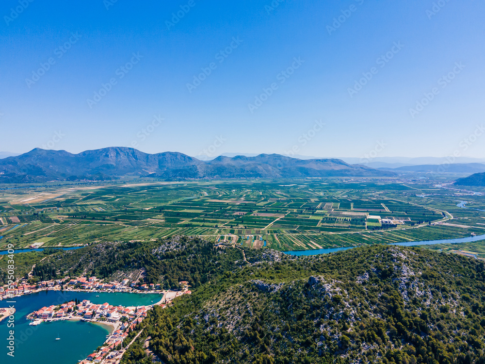Obraz premium Fertile Neretva River Delta and coastal village of Blace, Croatia – lush green fields, Adriatic sea