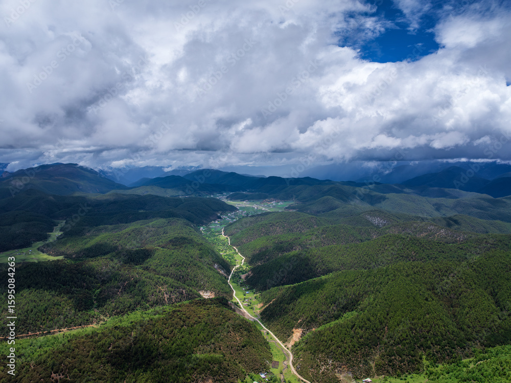 Naklejka premium Aerial view of forested valleys under clouds