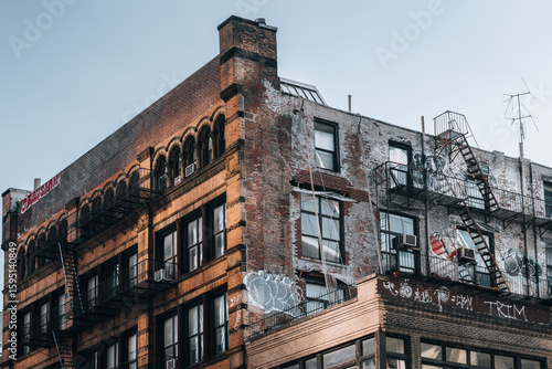 A building with a lot of graffiti on it. The building is old and has a lot of windows