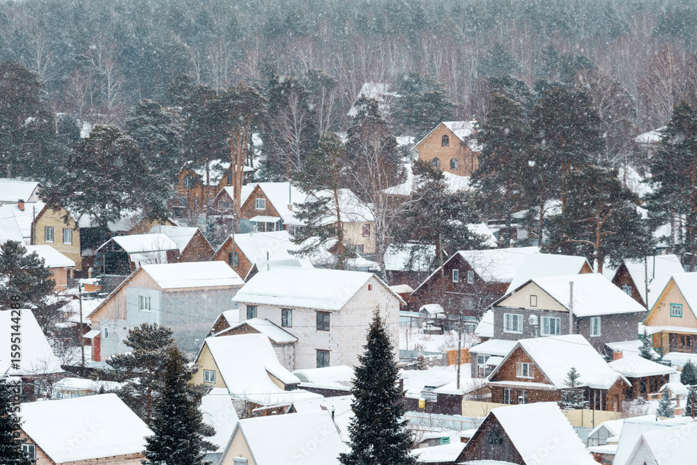 Obraz premium Nestled in a quiet area, the village is draped in soft white snow, transforming each house into a picturesque winter