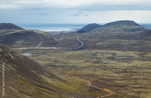 Aerial view of the parking lot, the road, and tourists making their way up the trail towards Fagradalsfjall Volcano, which has erupted several times, near the town of Grindavík in southwestern Iceland