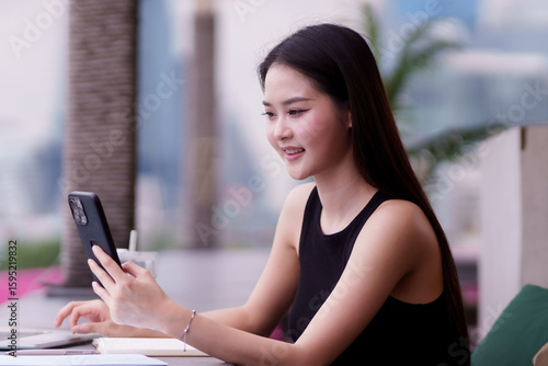Modern Asian adult woman business professional confidently working laptop smartphone connecting online urban cafe Free Download Modern Asian adult woman business professional confidently working laptop smartphone connecting online urban cafe - GFXLoad