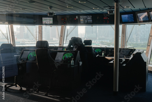 Photos modern ship navigation bridge with captain overlooking the urban landscape