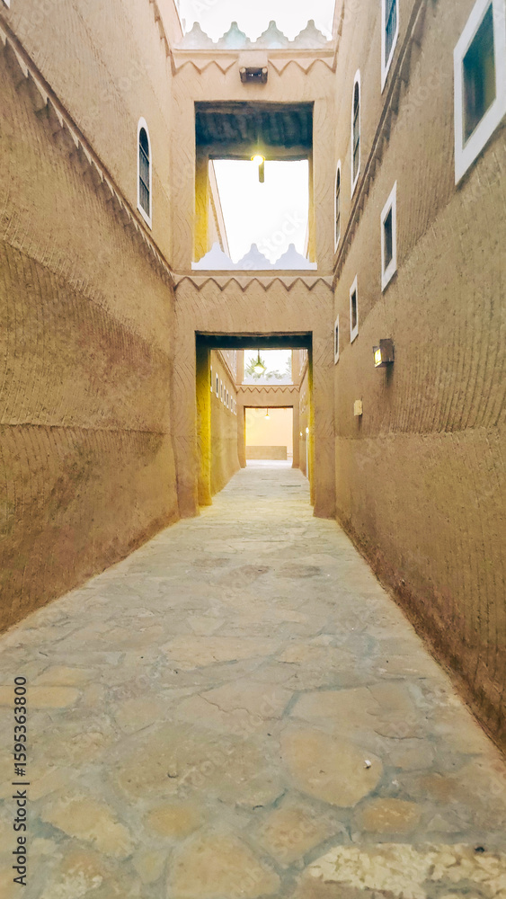 Obraz premium Narrow alleyway in a traditional old town with mud brick architecture in Riyadh, Saudi Arabia