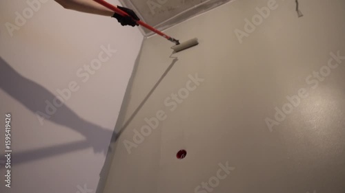 Men's hands paint walls with a roller, work painting on the surface, painting walls in an apartment, repair with white paint. High quality 4k footage