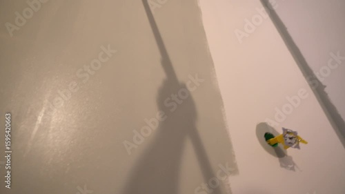 The view from below is like a master who paints the walls with a roller in gray. Apartment painting, renovation. High quality 4k footage