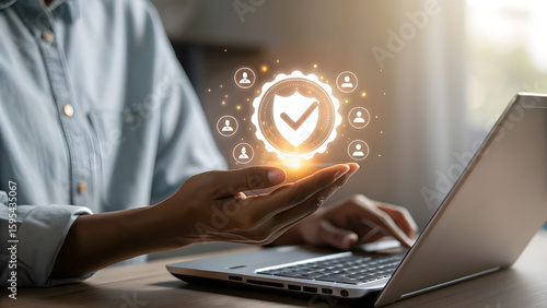 Person using a smartphone and laptop with a glowing digital security shield and user icons symbolizing data protection and online safety