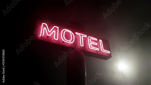 Neon motel sign glowing at night in the fog. Night scene.