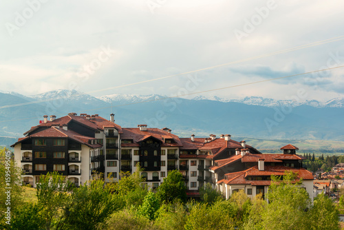 View of several guesthouses nestled in a valley below the Pirin Mountains in Bansko, a touristy town in southeastern Bulgaria