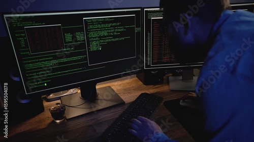 Programmer trying to fend off system hacking. Hacker writing scripts in a dark room. Digital threats, data breaches, online vulnerability in the modern cyber world.