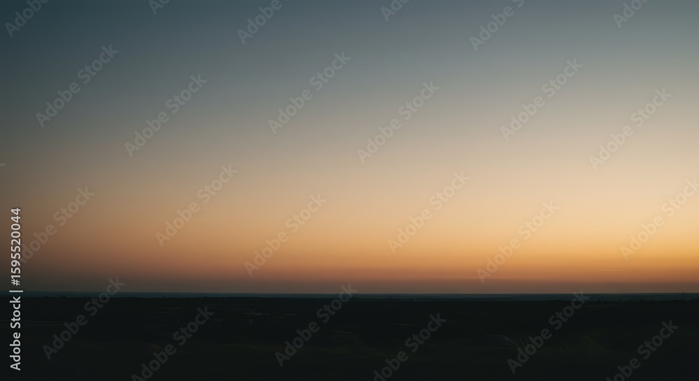 Fototapeta premium A serene sunset sky over a dark landscape