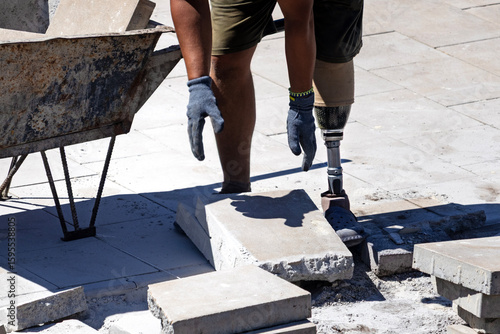 A man with a prosthetic leg works on a construction site. Prosthetic leg.	