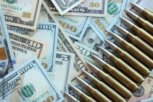 Yellow cartridges and bullets on dollar bills